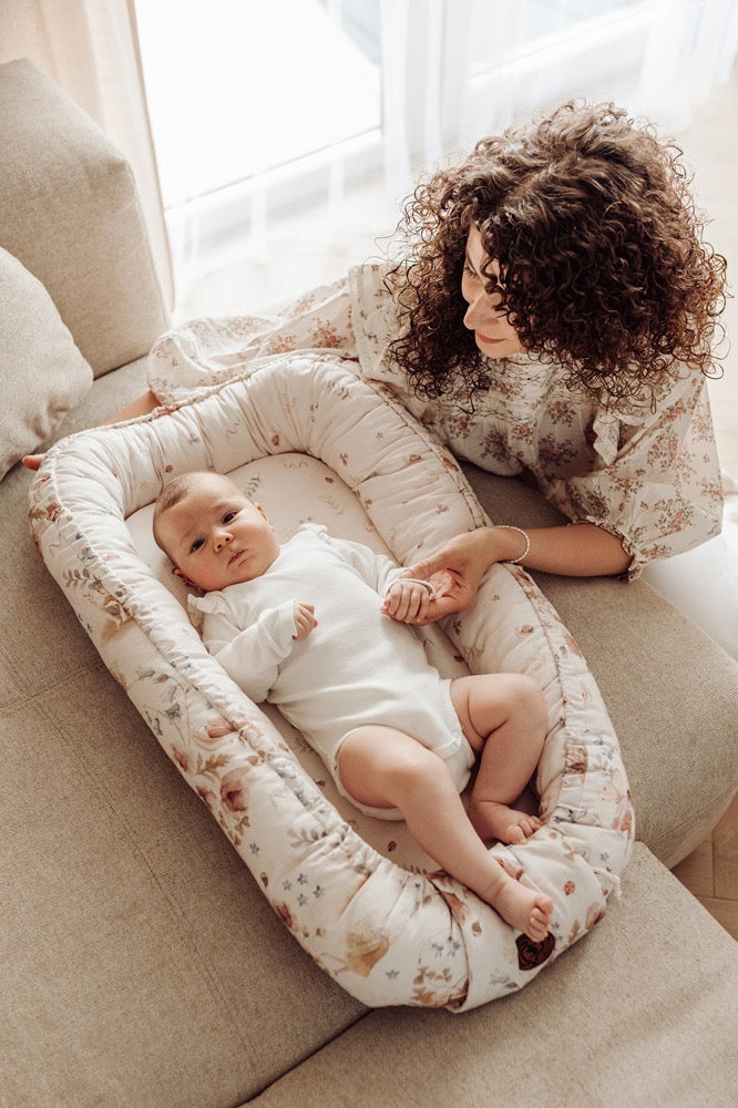 Een knus en zacht baby nest in een lichte kleur met een subtiel patroon van konijntjes en tarwearen, perfect voor pasgeborenen. Het nestje heeft verhoogde randen voor extra veiligheid en geborgenheid en is gemaakt van ademend, anti-allergisch katoen. Ideaal voor gebruik in een wieg, bed of op reis.